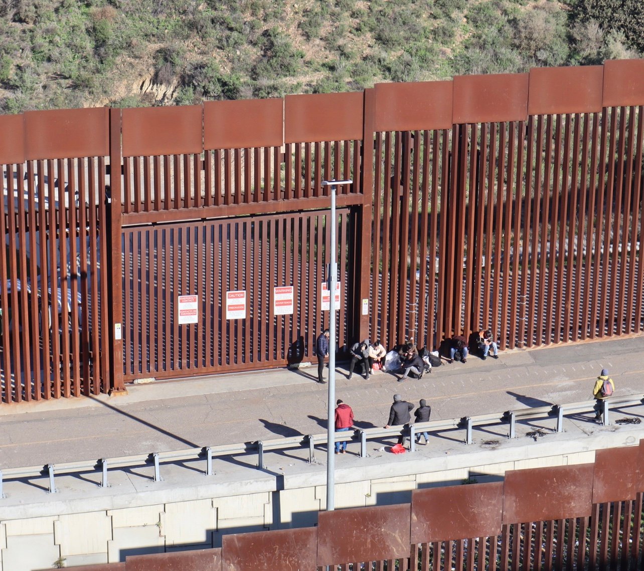 Migrants cross illegally through the wall into the United States